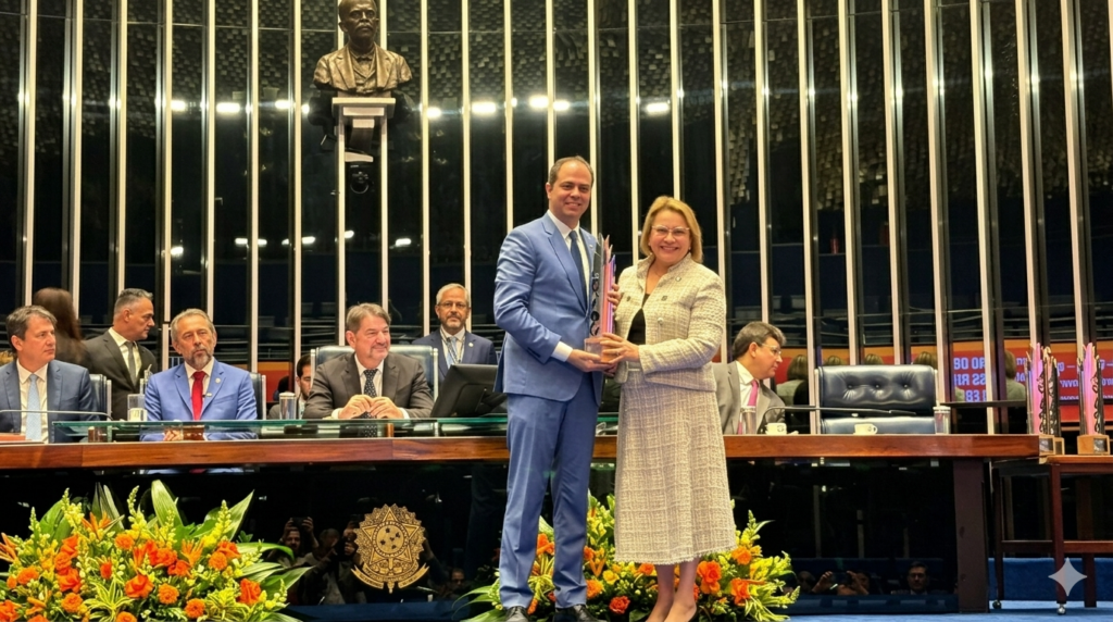 Juliano Manzeppi, secretário de representação de Mato Grosso, recebe a Comenda Governadores pela Alfabetização das Crianças na Idade Certa no plenário do Senado Federal em Brasília. Ao fundo, mesa diretora com autoridades e busto de Rui Barbosa.